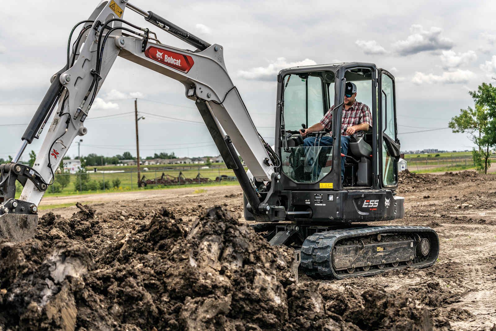 Operator digging with a Bobcat E55 compact excavator