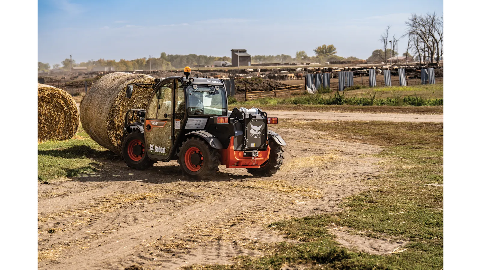 Bobcat TL519 telehandler carrying a round bale with a bale fork