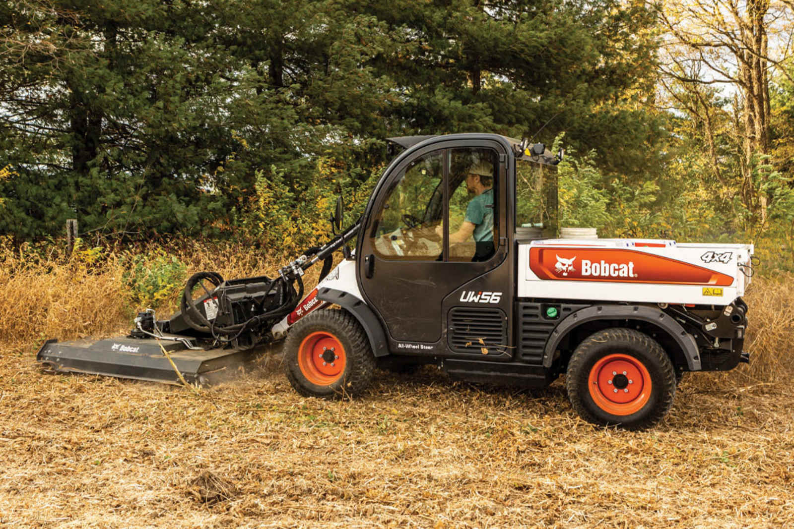 Bobcat UW56 Toolcat utility work machine cutting overgrown brush with a Brushcat rotary cutter
